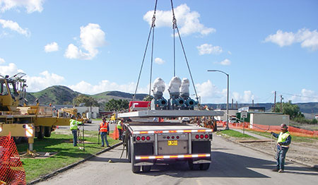 IMAGE 3: Workers carefully guide the prefabricated wet well with mounted turbine pumps off the truck